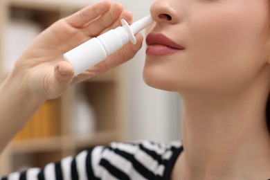 Medical drops. Woman using nasal spray at home, closeup