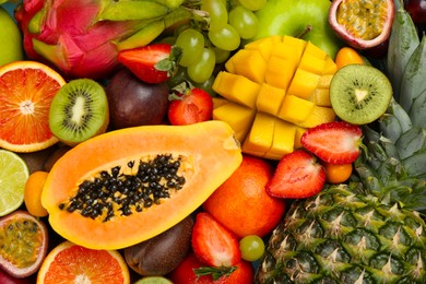 Photo of Many different delicious exotic fruits as background, top view