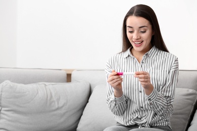 Photo of Young woman with pregnancy test at home. Gynecology and childbirth