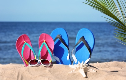 Composition with beach accessories on sand near sea in summer