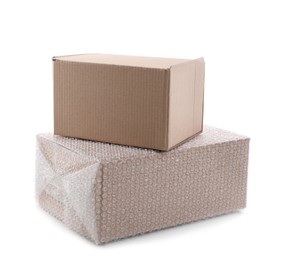 Cardboard box packed in bubble wrap and ordinary one on white background