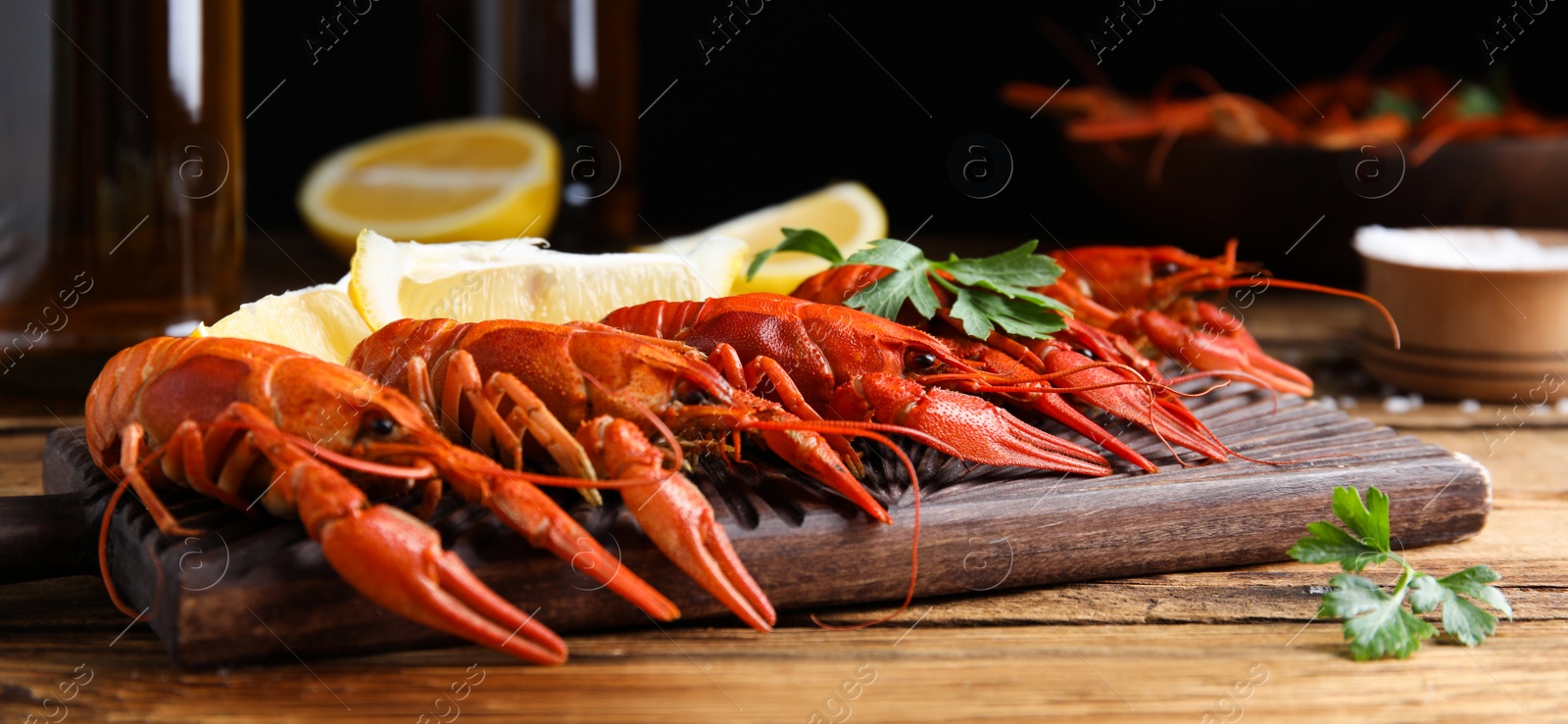 Image of Delicious red boiled crayfishes on table, closeup. Banner design