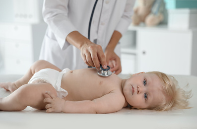 Pediatrician examining baby with stethoscope in hospital. Health care