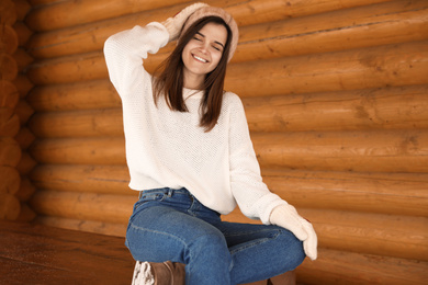 Photo of Pretty woman in sweater near wooden wall