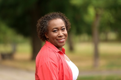 Photo of Portrait of happy African-American woman in park