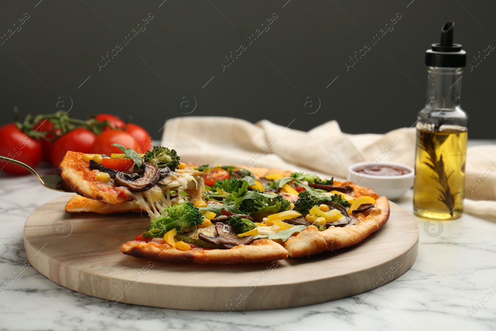 Photo of Taking piece of delicious vegetarian pizza at white marble table, closeup