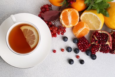 Photo of Flat lay composition with cup of delicious immunity boosting tea and ingredients on light grey table