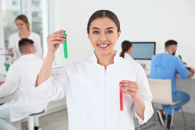 Portrait of medical student with test tubes in modern scientific laboratory