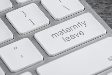 Image of Modern computer keyboard with text MATERNITY LEAVE, closeup