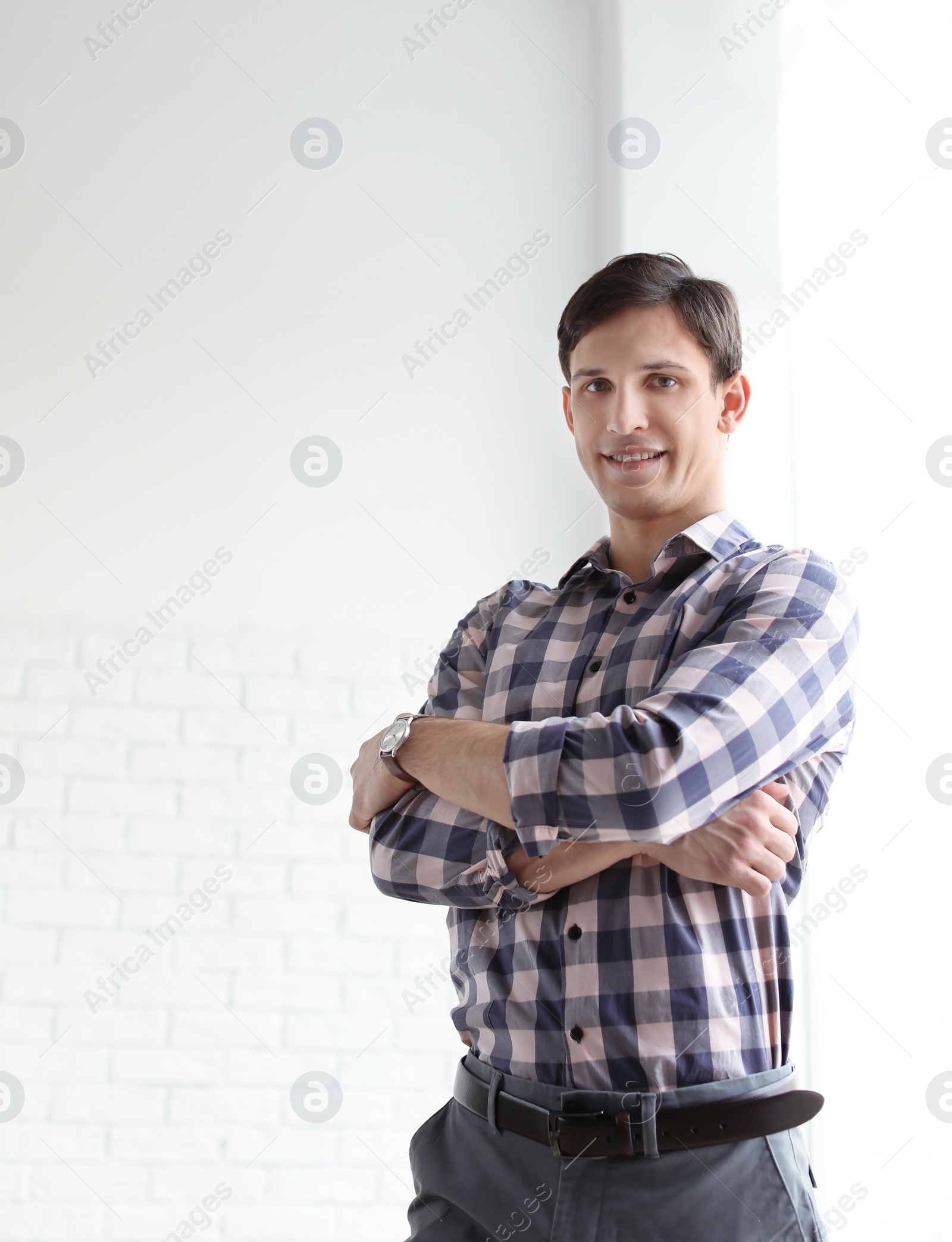 Photo of Portrait of confident young man near window, indoors