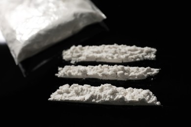 Photo of Drug addiction. Cocaine on black table, closeup