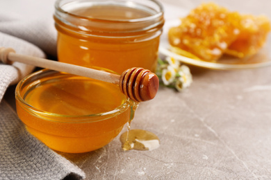 Photo of Tasty honey on brown marble table, closeup