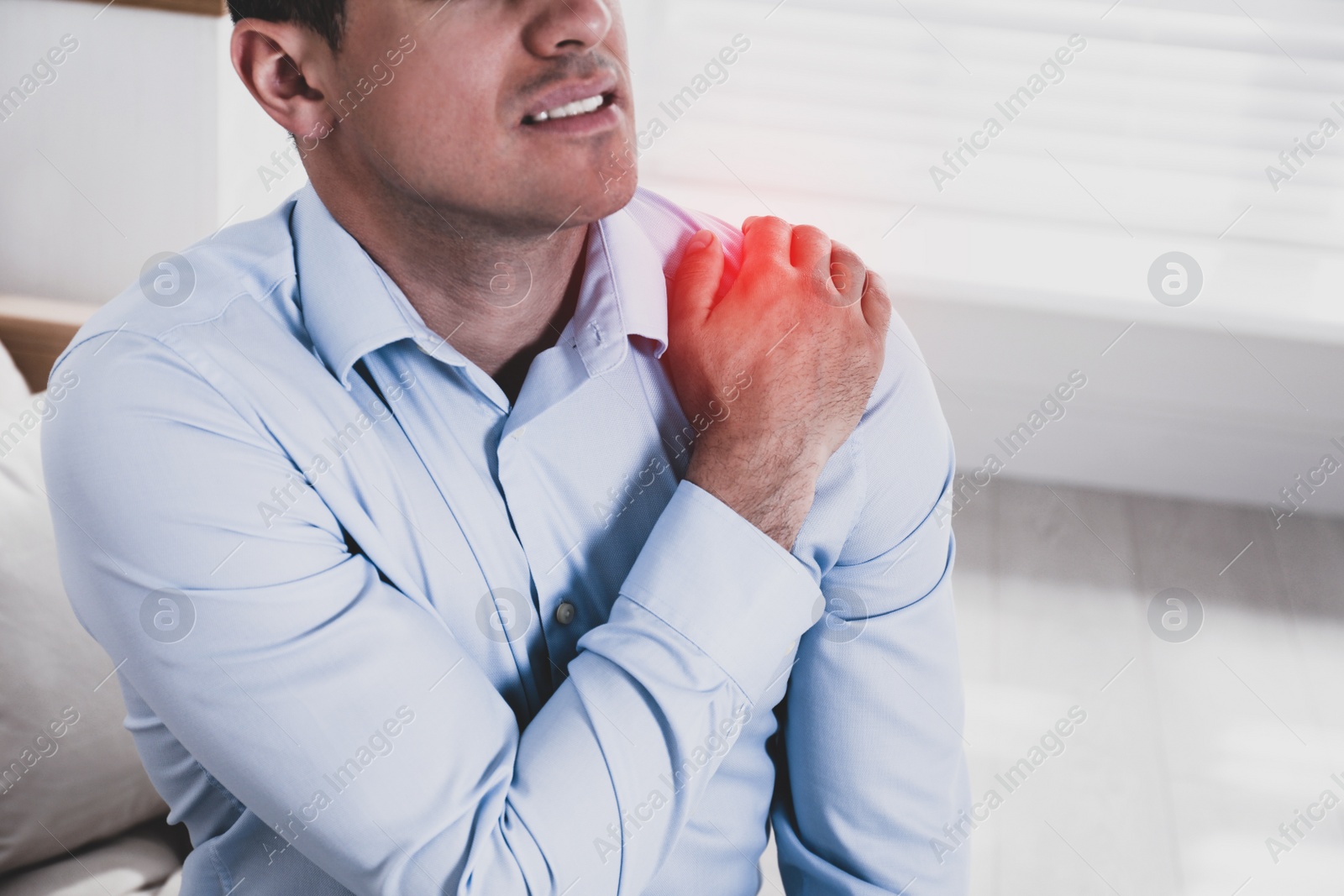 Image of Man suffering from shoulder pain at home, closeup