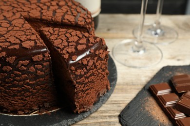Photo of Delicious chocolate truffle cake on wooden table, closeup