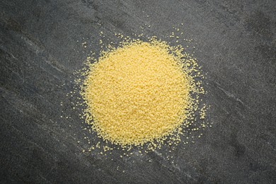Heap of raw couscous on grey table, top view