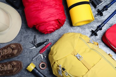 Photo of Flat lay composition with backpack and other camping equipment for tourism on grey background