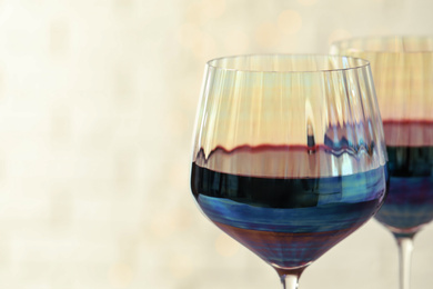 Glasses of red wine on light background, closeup. Space for text