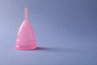 Photo of Menstrual cup on blue background. Space for text