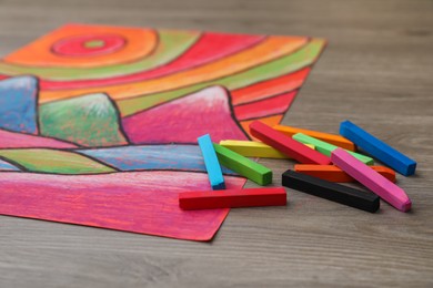 Beautiful drawing and pastels on wooden table, closeup view