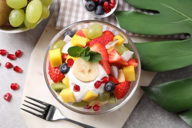 Photo of Delicious fruit salad on grey table, flat lay