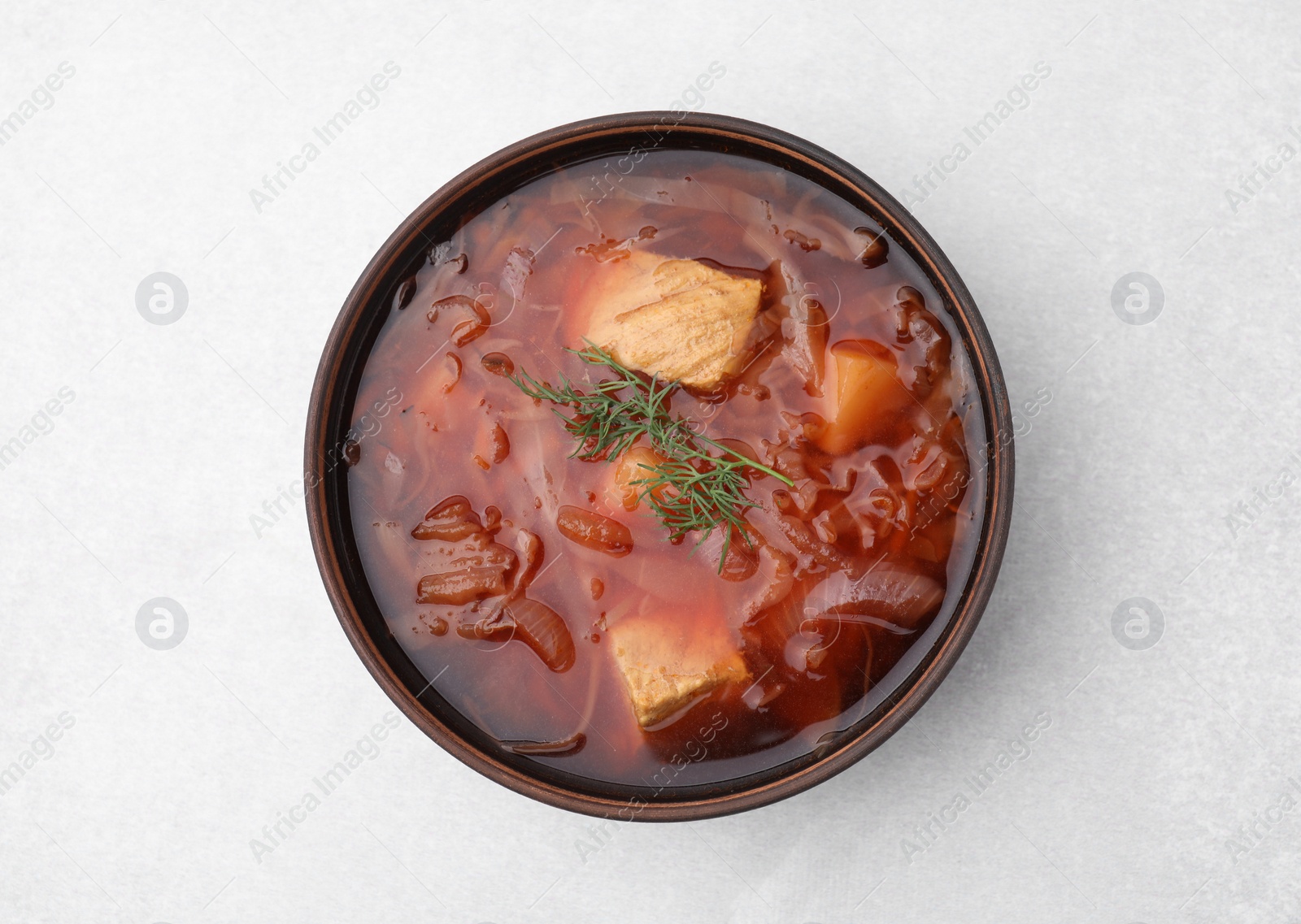 Photo of Bowl of delicious borscht on white table., top view