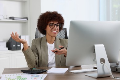 Photo of Professional accountant having video chat via computer at desk in office