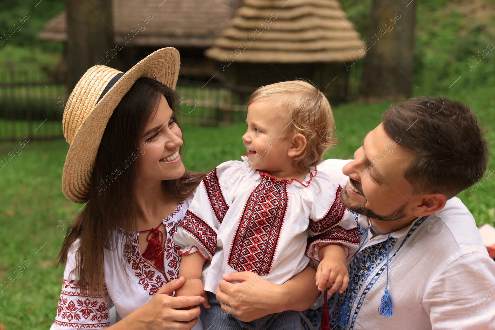 Photo of Happy family in Ukrainian national clothes outdoors