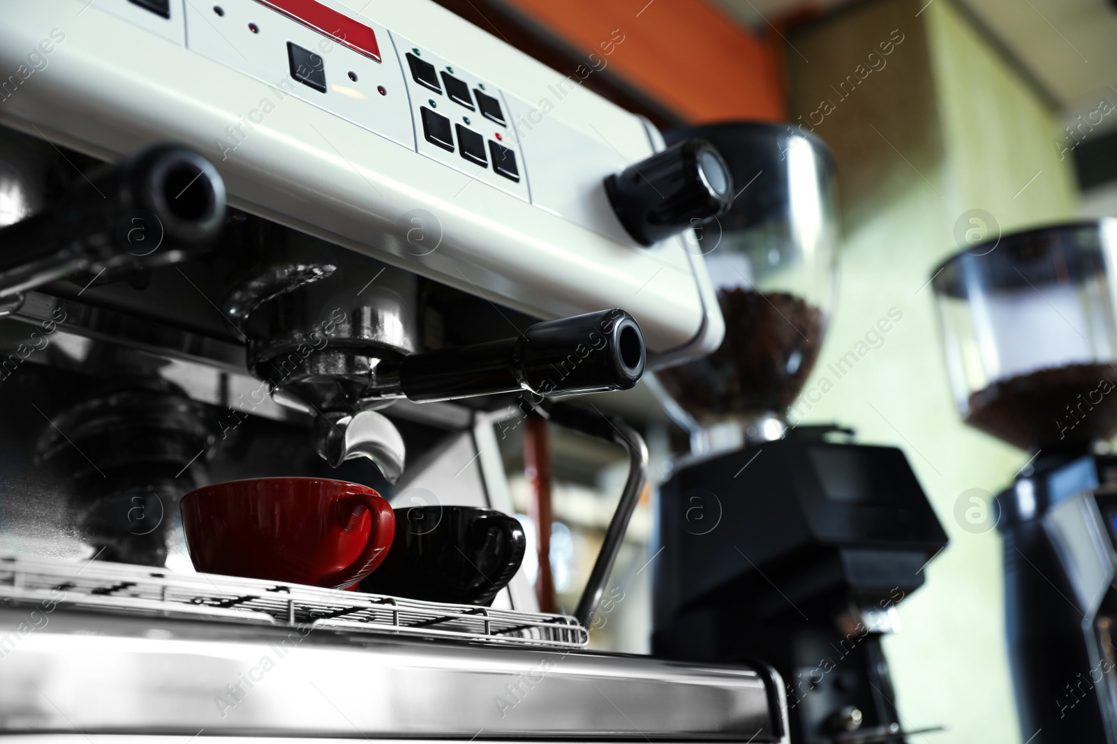 Photo of Modern coffee machine with cups in cafe, low angle view. Space for text