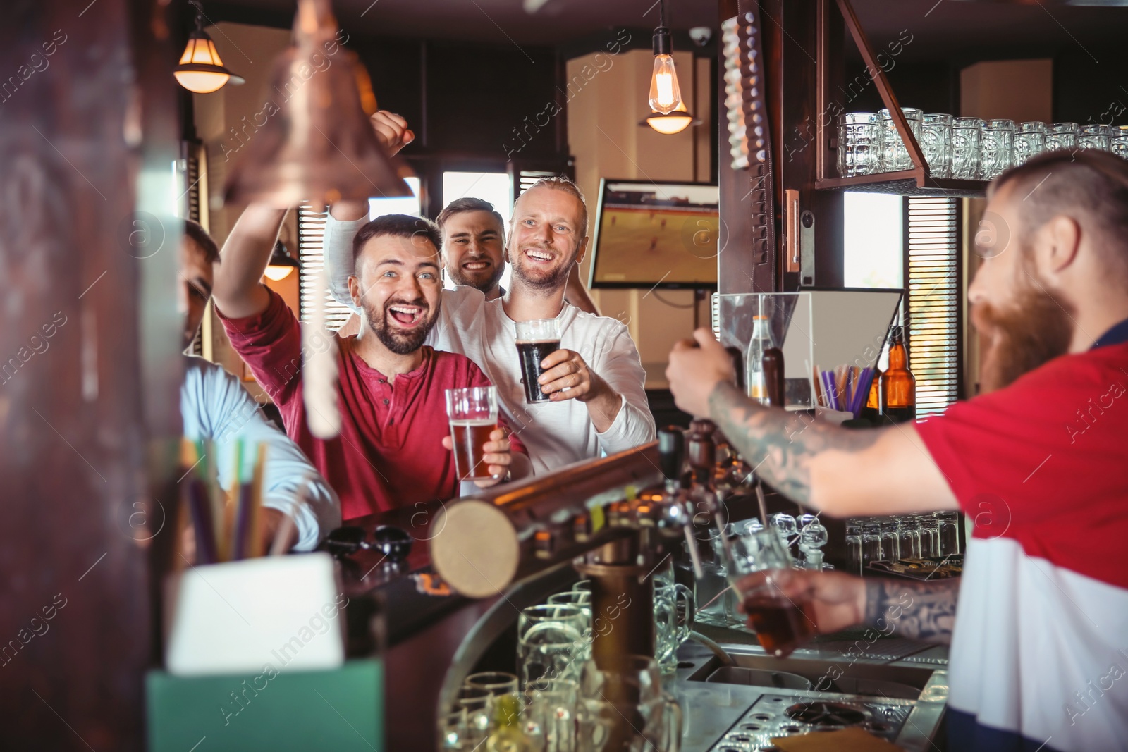 Photo of Friends drinking beer at counter in bar