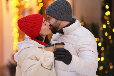 Lovely couple with hot drinks spending time together outdoors