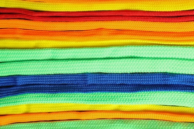 Photo of Colorful shoelaces as background, closeup. Stylish accessory