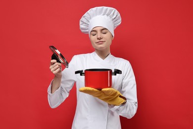 Photo of Professional chef with cooking pot on red background