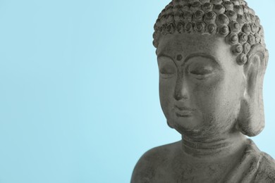 Photo of Beautiful stone Buddha sculpture on light blue background. Space for text