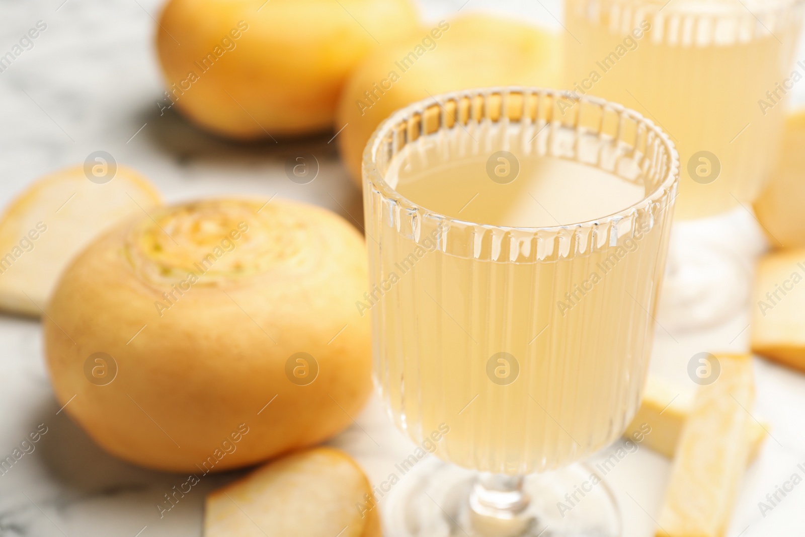 Photo of Glass of freshly made turnip juice on white table, closeup