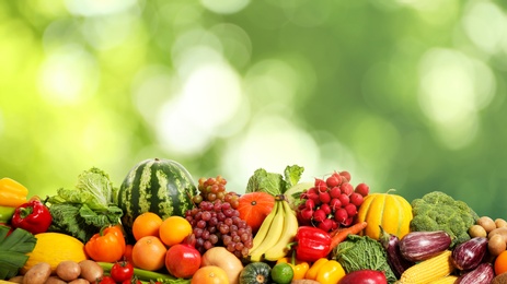 Image of Assortment of fresh organic vegetables and fruits on blurred green background 