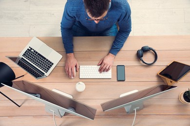 Photo of Programmer working at desk in office, top view