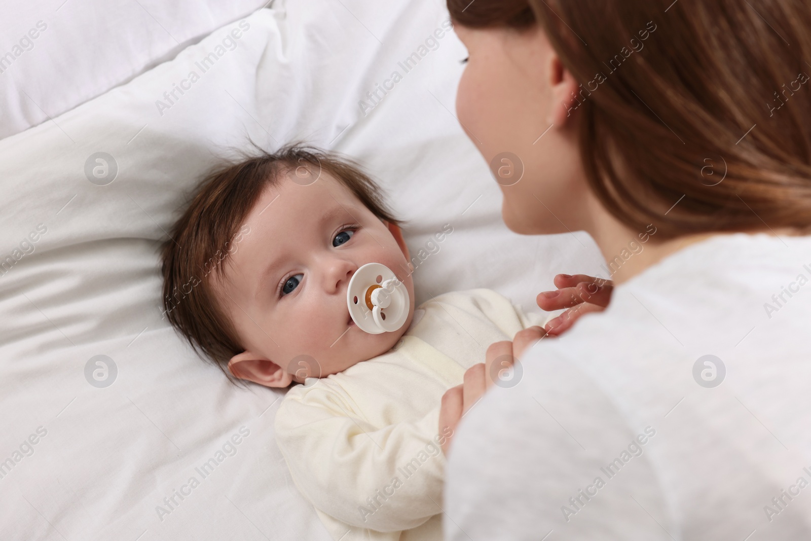 Photo of Mother with her little baby on bed, closeup