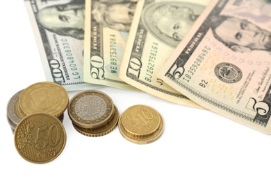 Photo of Dollar banknotes and stacks of coins on white background, closeup