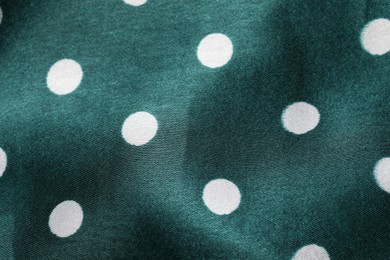 Texture of green polka dot fabric as background, top view