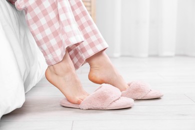 Photo of Woman in pink soft slippers at home, closeup