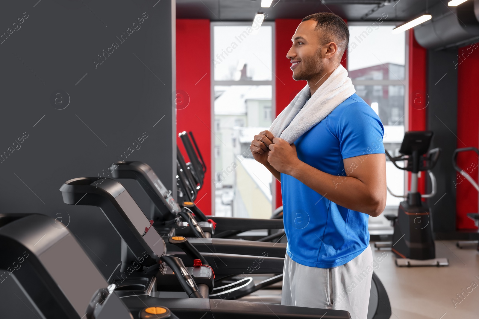 Photo of Happy trainer in modern gym, space for text