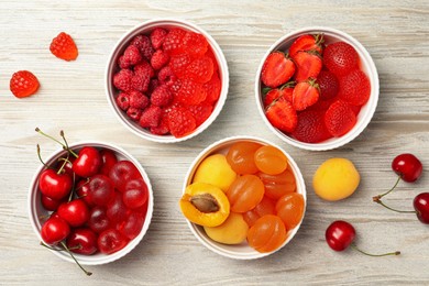 Delicious gummy candies and fresh fruits on white wooden table, flat lay