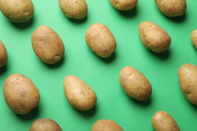 Photo of Fresh raw potatoes on green background, flat lay