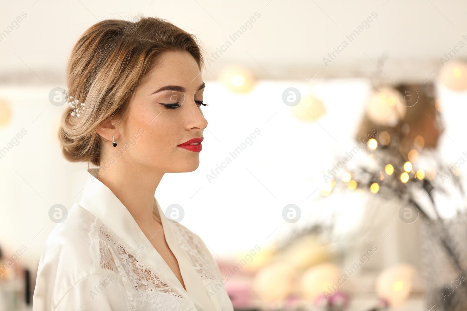 Photo of Beautiful young bride with makeup created by professional artist indoors. Wedding preparation