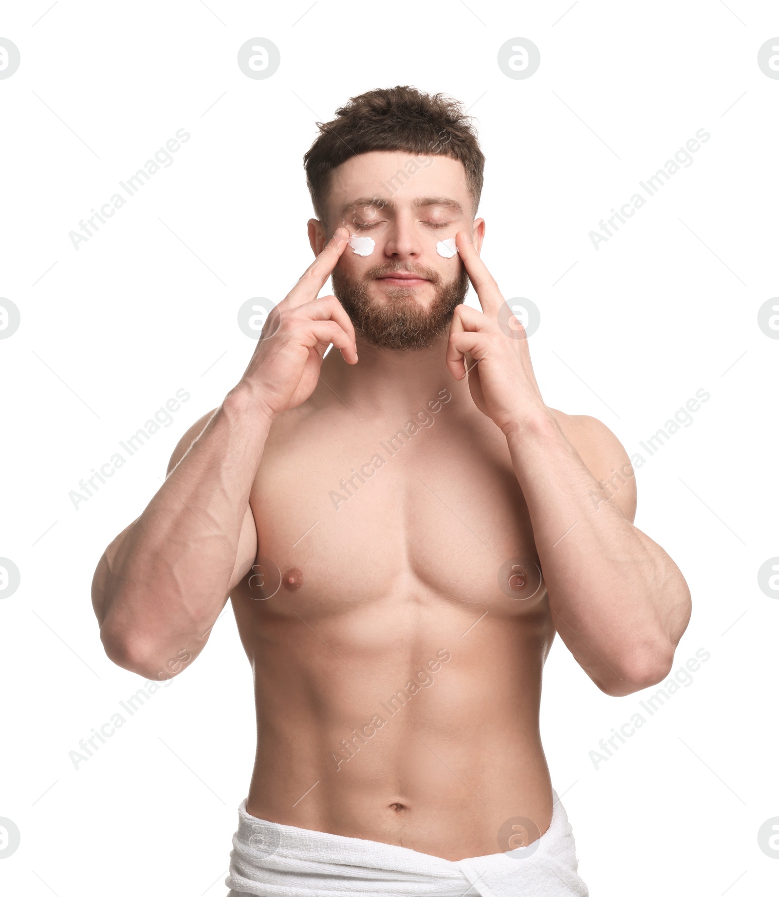 Photo of Handsome man applying moisturizing cream onto his face on white background