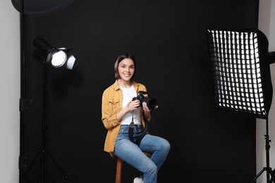 Professional photographer with camera in modern photo studio