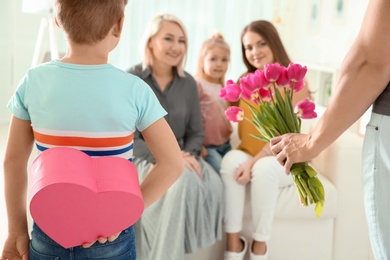 Photo of Little boy and his father congratulating their family at home