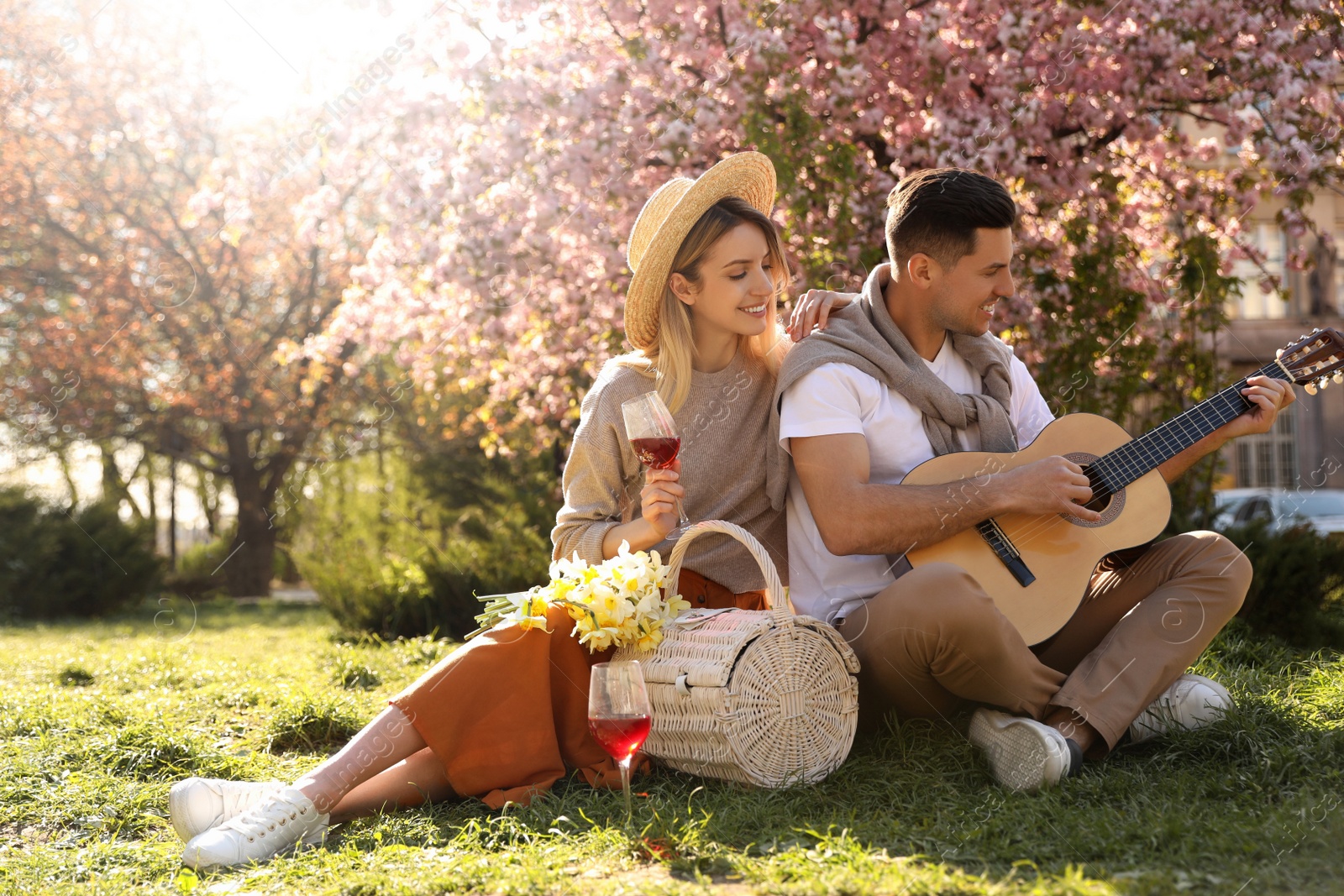 Photo of Lovely couple having picnic in park on sunny spring day