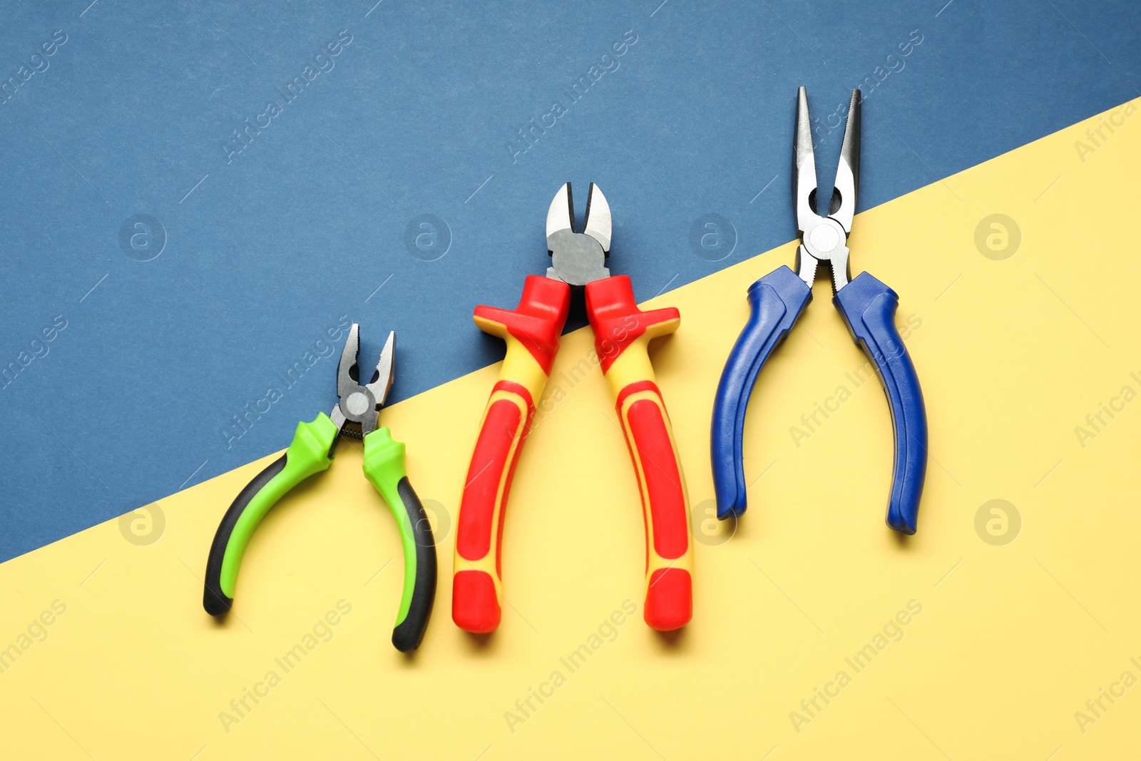 Photo of Different pliers on color background, flat lay