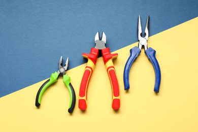 Photo of Different pliers on color background, flat lay